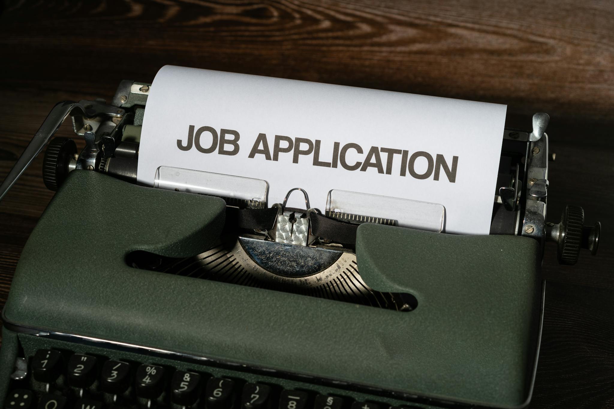 Close-up of a vintage typewriter with a job application paper inserted.